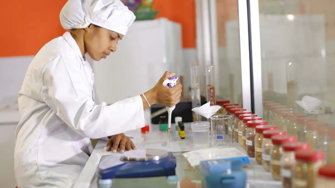 A lab employee conducting tests at rice research and development facility at CIC