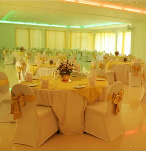 Banquet hall arranged with white color tables and chairs at CIC Agri resort